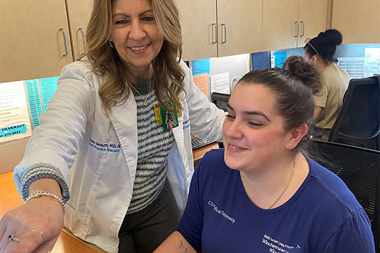 Two staff members smiling at a computer